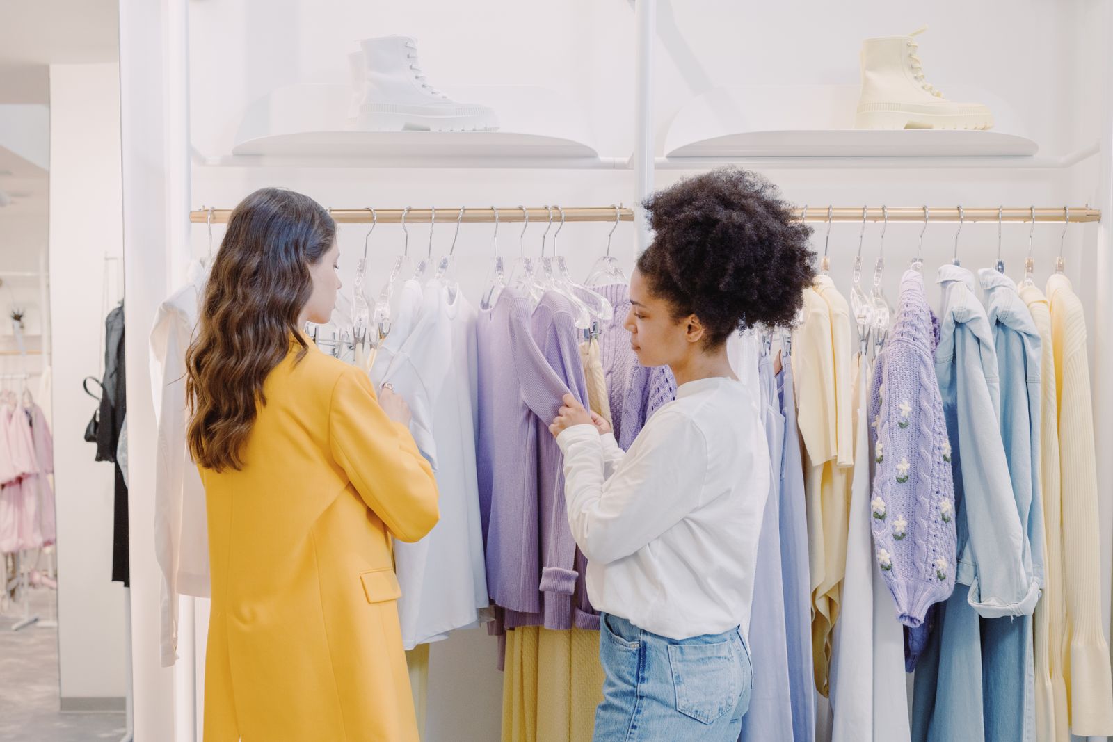 Stylist guiding a client through a rail of clothes