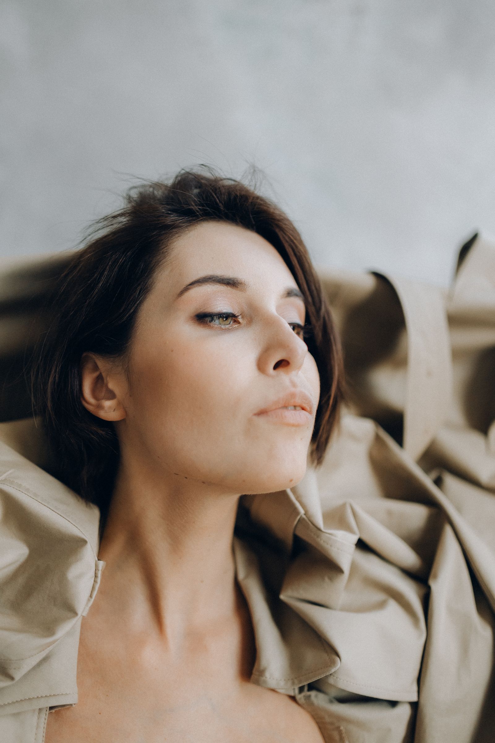 Close-up portrait of a woman in a beige coat
